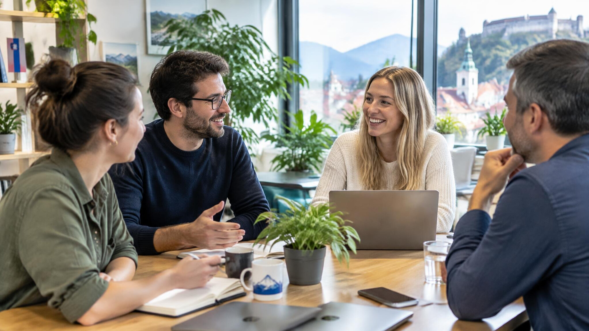 Team of colleagues having a friendly meeting around a table in a bright office